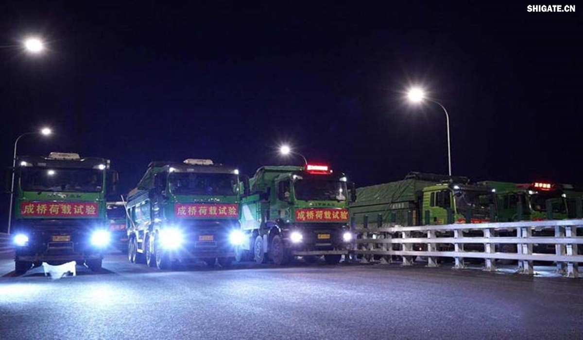 6月16日22時，世界最大跨度斜拉橋——常泰長江大橋燈火通明，車聲轟鳴，一場通車前的“極限挑戰(zhàn)”正緊張進(jìn)行。30輛總重達(dá)1200噸的四軸加載車，分批列隊駛上橋面預(yù)先劃定的停靠點，并由提前布置在橋梁各關(guān)鍵部位的869個傳感器開展實時監(jiān)測，采集測試數(shù)據(jù)。由此，大橋跨江公鐵合建段主橋橋梁荷載試驗全面啟動。    AA1GQ79M.jpg    這次荷載試驗覆蓋范圍具體包括1座主跨1208米斜拉橋、2座主跨388米鋼桁拱專用航道橋、1座非通航道孔橋以及南北兩座引橋，共設(shè)計119個靜載工況和111個動載工況。其中，最大對稱靜力加載工況將動用110輛四軸加載車，總重達(dá)4400噸。試驗將持續(xù)一周，分五個階段進(jìn)行。試驗首日在錄安洲非通航孔橋和常州側(cè)公鐵合建段引橋?qū)嵤? 常泰長江大橋是連通常州與泰興的跨江通道，是長江上首座集高速公路、城際鐵路和普通公路三種功能于一體的雙層復(fù)合型橋梁，計劃于今年年內(nèi)基本建成。它的上層為雙向六車道高速公路，下層為雙線城際鐵路和普通公路。如此復(fù)雜的結(jié)構(gòu)，如何確保它在未來百年服役中安全可靠？答案就藏在荷載試驗中。    AA1GQduQ.jpg    荷載試驗堪稱橋梁通車前的“綜合大考”，是確保橋梁安全運(yùn)營的“體檢報告”。江蘇省交通工程建設(shè)局常泰長江大橋建設(shè)指揮部現(xiàn)場常務(wù)副指揮長夏鵬飛介紹，“荷載試驗是檢測橋梁結(jié)構(gòu)安全和承載能力的重要手段，通過科學(xué)的加載測試和數(shù)據(jù)采集分析，驗證實際成橋狀態(tài)與理論設(shè)計的鍥合度，確保常泰長江大橋運(yùn)營安全。”考慮到大橋主體采用鋼結(jié)構(gòu)和鋼-混凝土組合結(jié)構(gòu)，為最大限度減少晝夜溫差對測試數(shù)據(jù)的影響，所有試驗均安排在夜間實施。  通過一系列科學(xué)嚴(yán)謹(jǐn)?shù)暮奢d測試，這座世界級多功能大橋的實際性能將得到充分檢驗，為常泰長江大橋后續(xù)安全通車運(yùn)營提供至關(guān)重要的數(shù)據(jù)支撐。